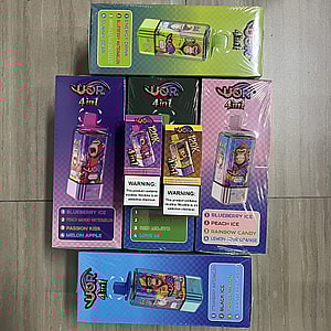 Six colorful rectangular WOR 4in1 vape product boxes featuring a cartoon monkey, visible flavor lists (e.g., Blueberry Ice, Peach Ice, Passion Kiss, Melon Apple, Rainbow Candy) and prominent nicotine warning labels arranged on a light tiled floor.