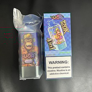 Disposable vape device wrapped in plastic featuring a cartoon gorilla label beside its colorful '120K 4-in-1' box bearing a nicotine addiction warning, shown on a black surface.
