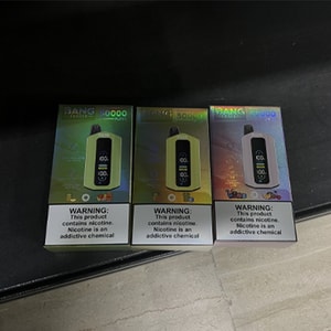 Three holographic boxed 'BANG 50000' disposable vape devices with visible nicotine warning labels displayed side by side on a dark tabletop.
