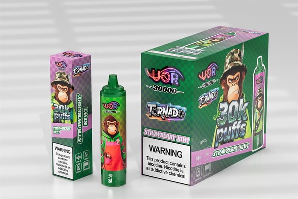 Three strawberry‑kiwi flavored disposable vape products—a tall rectangular retail box, a green cylindrical device, and a larger display box—featuring green-and-pink checkered packaging with a cartoon monkey in a camo hat, prominent “30K puffs” branding, and a visible nicotine warning label.