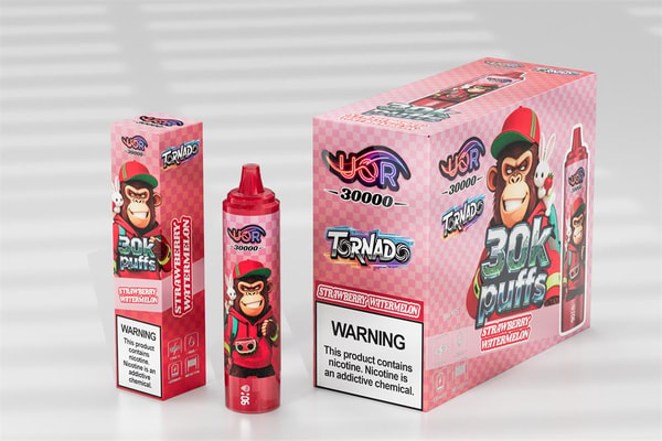 Pink checkered packaging for a strawberry‑watermelon disposable vape showing a red device and two boxes labeled “30K puffs” featuring a cartoon monkey in a cap and a prominent nicotine warning label.