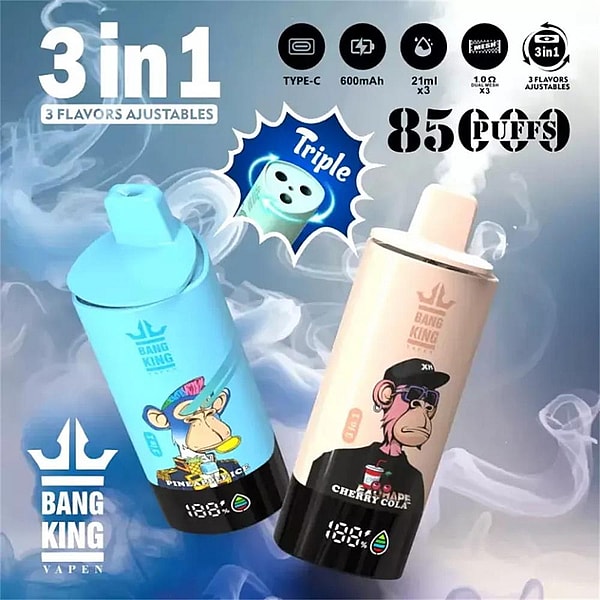 Dos dispositivos cilíndricos de vapeo Bang King, uno azul claro con un simio de dibujos animados con temática de piña y otro rosa pálido con un simio de cereza y cola, flotando sobre un fondo ahumado con íconos y texto que anuncia sabores triples 3 en 1, carga tipo C, batería de 600 mAh y 85 caladas.