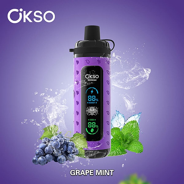 Purple cylindrical OKSO Shishai device with a black mouthpiece and a central digital display, surrounded by water splashes and foreground clusters of grapes and mint leaves, labeled Grape Mint.