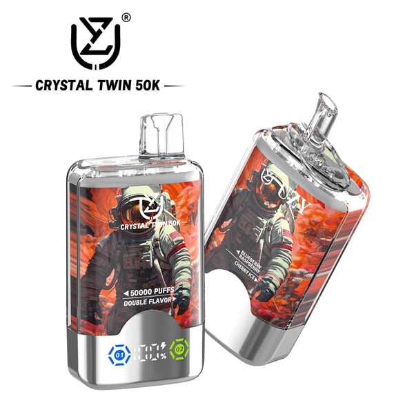 Two clear-topped metallic Crystal Twin 50K disposable vape devices with astronaut-in-orange-cloud artwork, labels reading 50,000 puffs and double flavor, and a small digital indicator, one standing upright and one tilted.