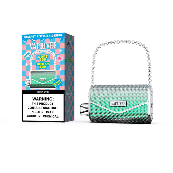 Metallic green and silver VAPRIVÉE portable vape styled like a textured mini-handbag with a chain handle, placed next to its colorful checkerboard box labeled Cherry Apple and a prominent nicotine warning.